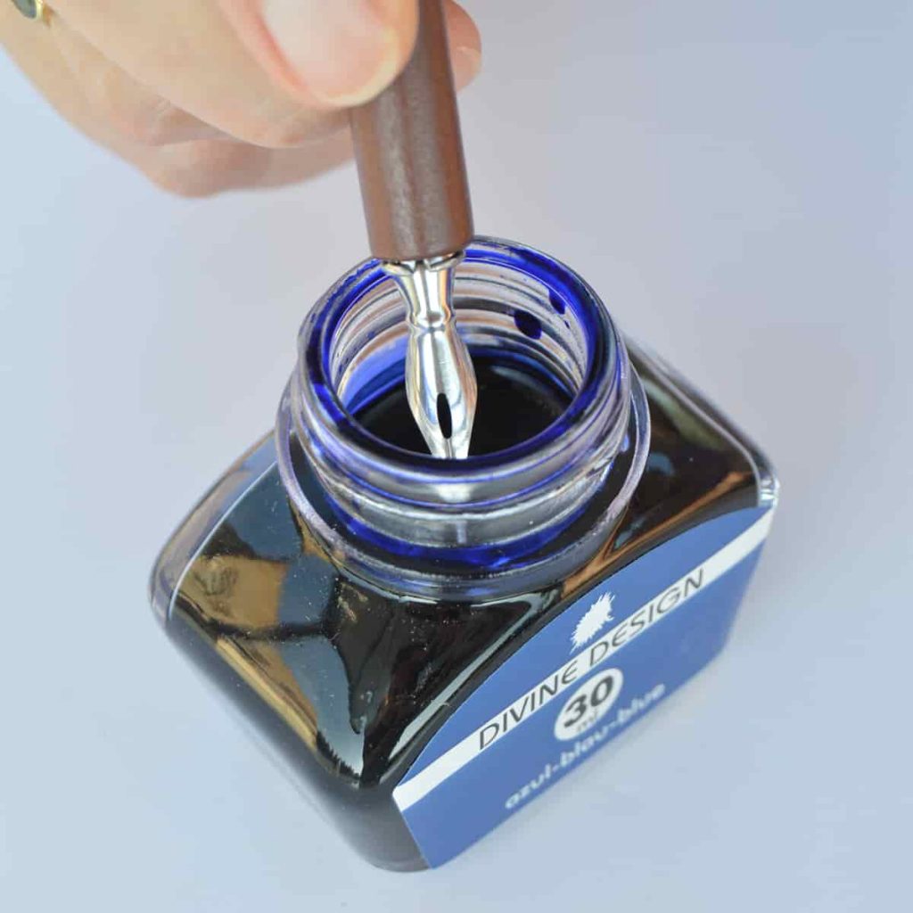 Tintero con tinta azul para plumas y plumillas