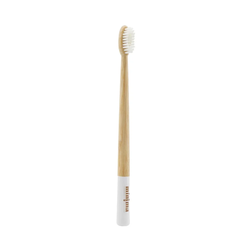 cepillo de dientes de bambú para adultos con cerdas blancas y franja blanca en el mango de mínima organics