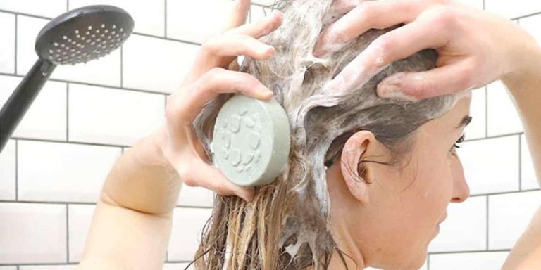 Mujer enjabonándose el cabello con champú sólido detalle