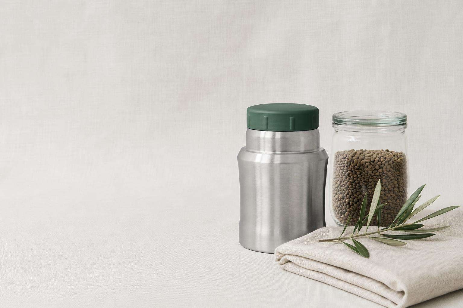 Termo de comida de acero inoxidable y tarro de vidrio con lentejas sobre lino: guardar comida sin plástico