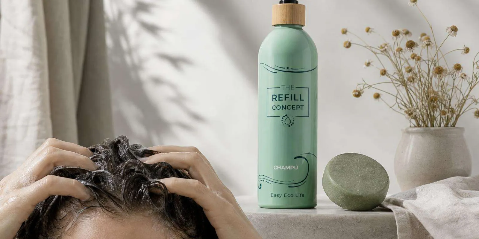 Manos aplicando champú sólido natural en el cuero cabelludo con masaje suave en baño minimalista