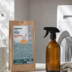 Lavadora con la puerta abierta junto a tarros de vidrio con percarbonato y ácido cítrico para una limpieza natural