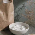 Bicarbonato de sodio en cuenco blanco con estropajo de cobre para limpiar el horno de forma natural