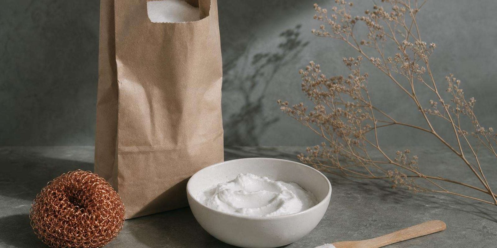 Bicarbonato de sodio en cuenco blanco con estropajo de cobre para limpiar el horno de forma natural
