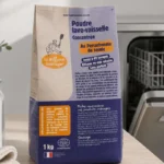 Lavavajillas abierto y limpio junto a un tarro de ácido cítrico y una bayeta en una cocina serena