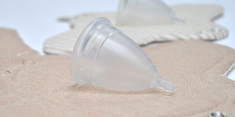 Copa menstrual de silicona transparente sobre compresas de tela reutilizables de algodón, alternativas para una menstruación sin residuos